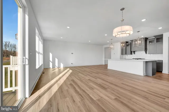 a view of a kitchen with kitchen island a large counter space a sink appliances and cabinets