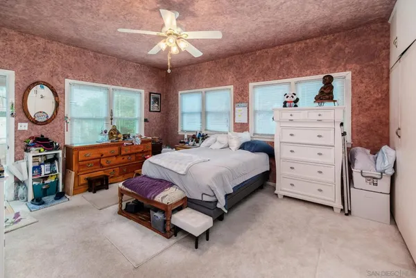 a spacious bedroom with a bed and a chandelier