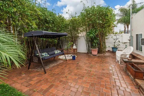 a backyard of a house with barbeque oven table and chairs