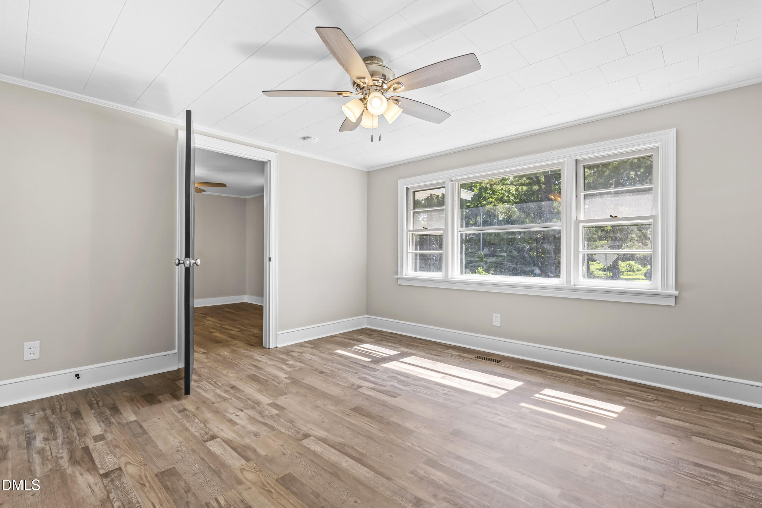 5511 Flower Hill Road Kenly, NC 27542 - Photo 14 of 33 an empty room with wooden floor chandelier fan and windows