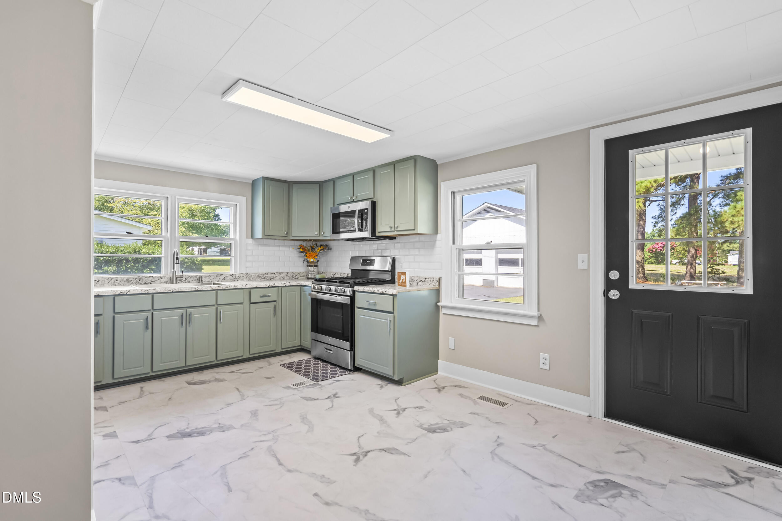 5511 Flower Hill Road Kenly, NC 27542 - Photo 16 of 33 a kitchen with a stove a sink and a refrigerator