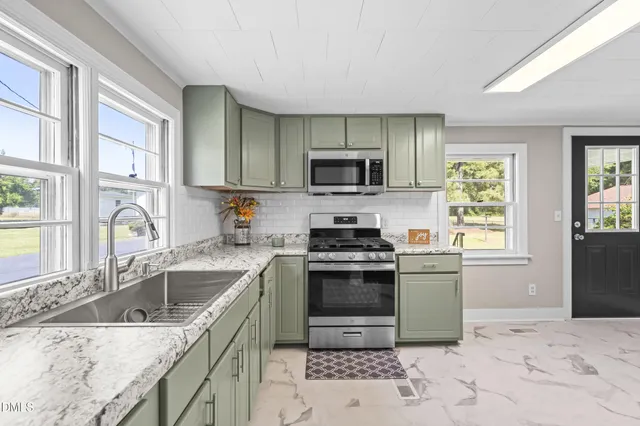 a kitchen with a sink stove top oven and refrigerator