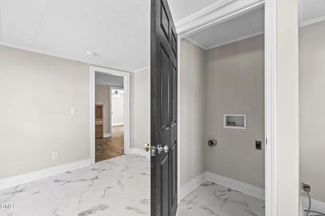 a view of a hallway with a livingroom and bathroom space