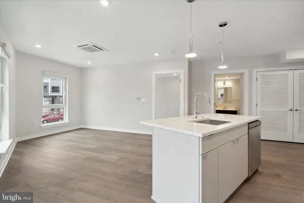 a view of a kitchen island a sink and dishwasher with wooden floor
