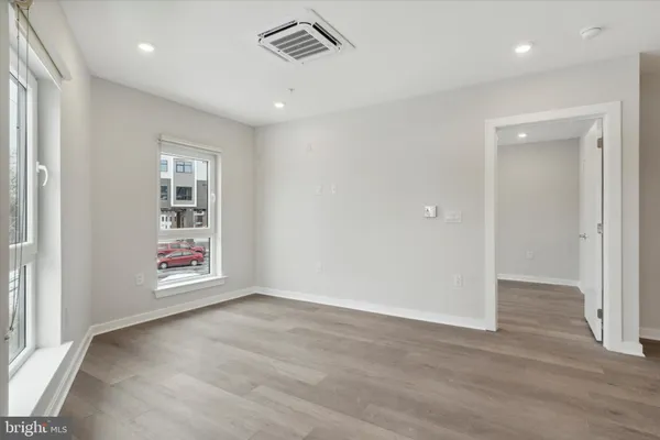 an empty room with wooden floor and window