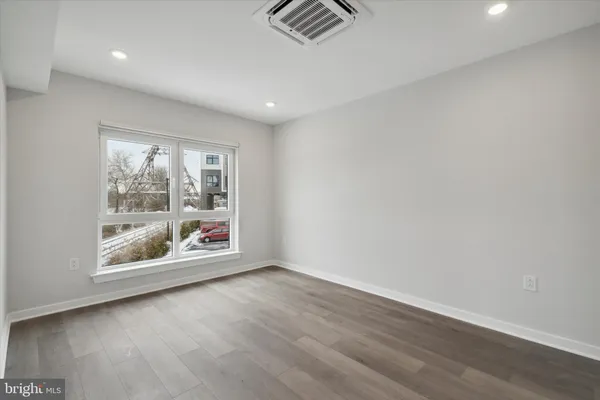 an empty room with wooden floor and window
