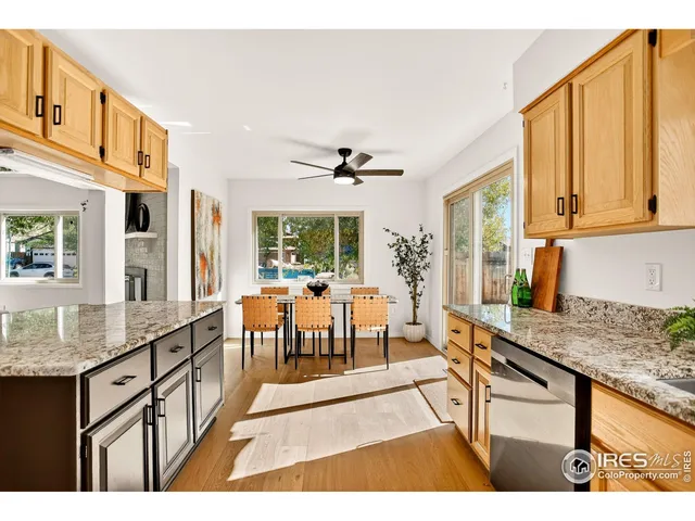 a view of a kitchen with kitchen island granite countertop wooden floor and a dining table