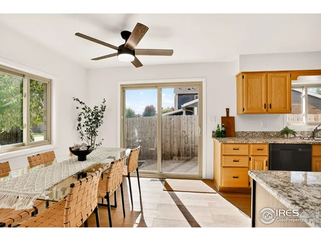 a open kitchen with granite countertop a stove a sink a dining table and chairs