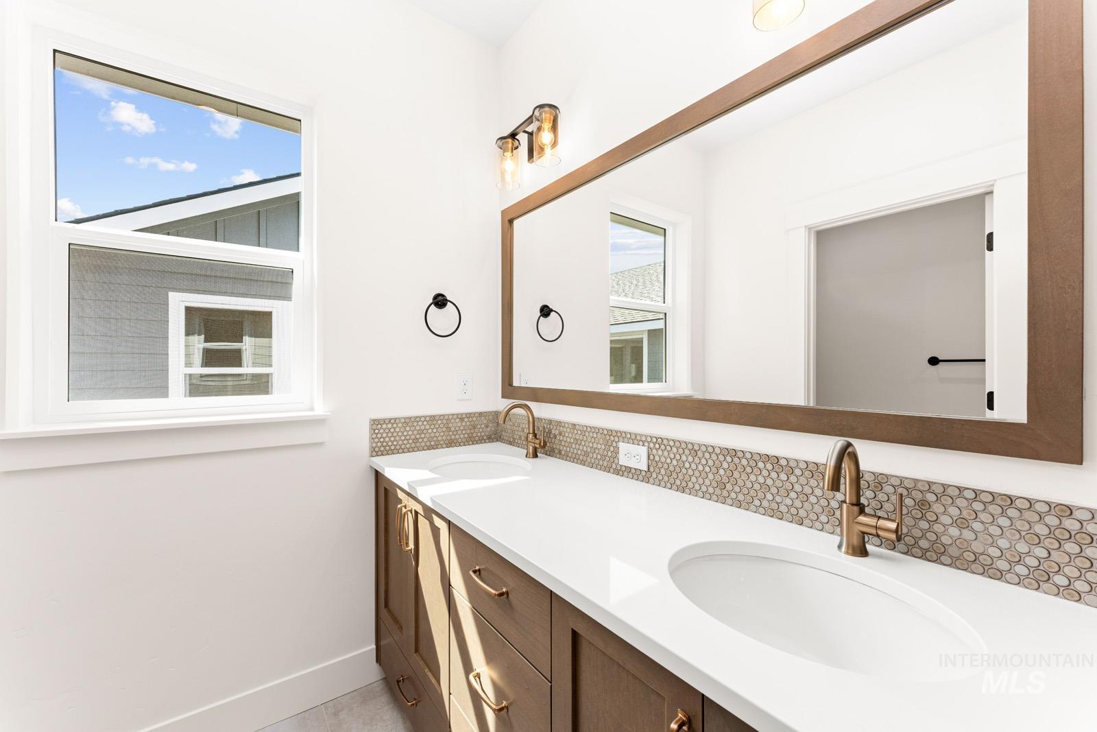 13344 North Spring Creek Way Boise, ID 83714 - Photo 23 of 39 Bathroom with double vanity and baseboards