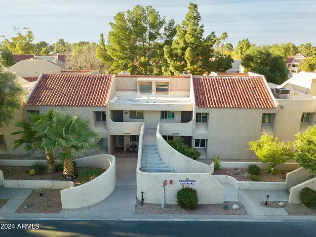 an aerial view of residential building with parking and city view