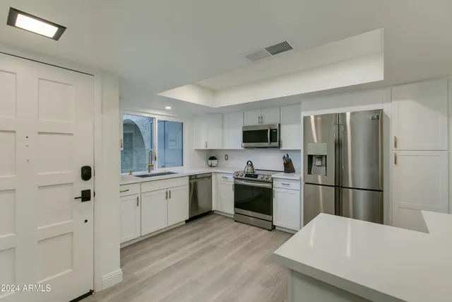 a kitchen with stainless steel appliances a refrigerator sink and microwave