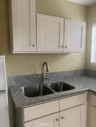 a kitchen with white cabinets and a sink