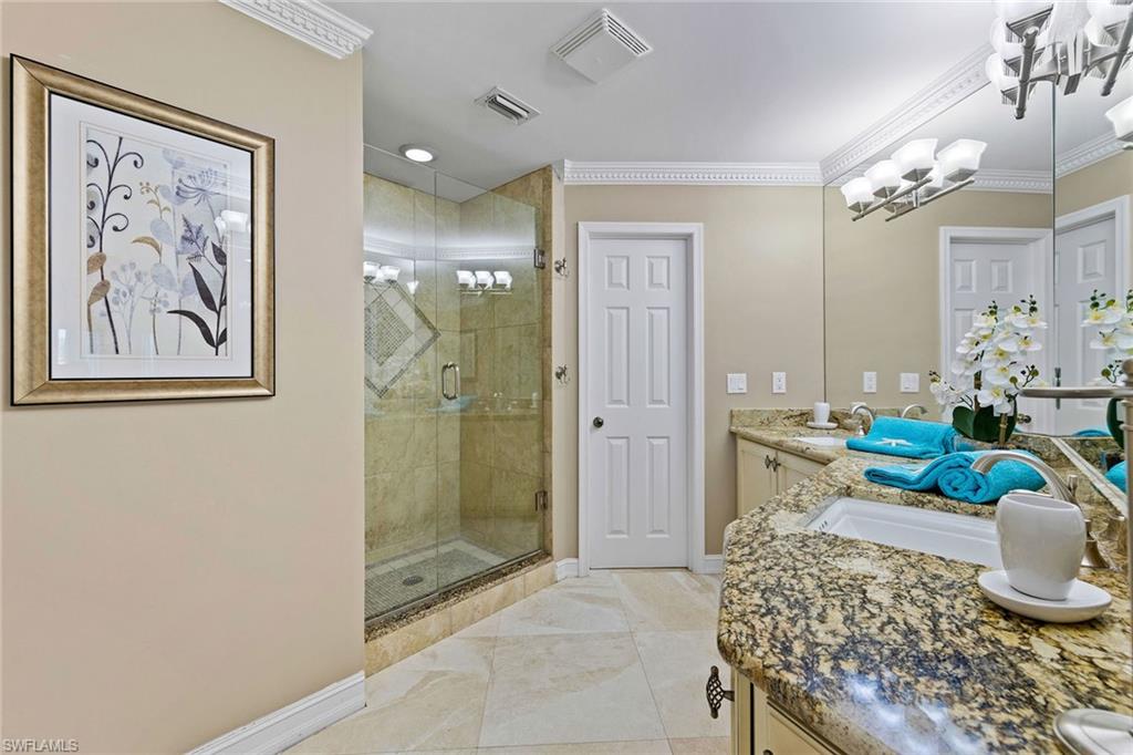 9101 Vanderbilt Drive, Unit 301 Naples, FL 34108 - Photo 13 of 28 a bathroom with a granite countertop sink a toilet and shower