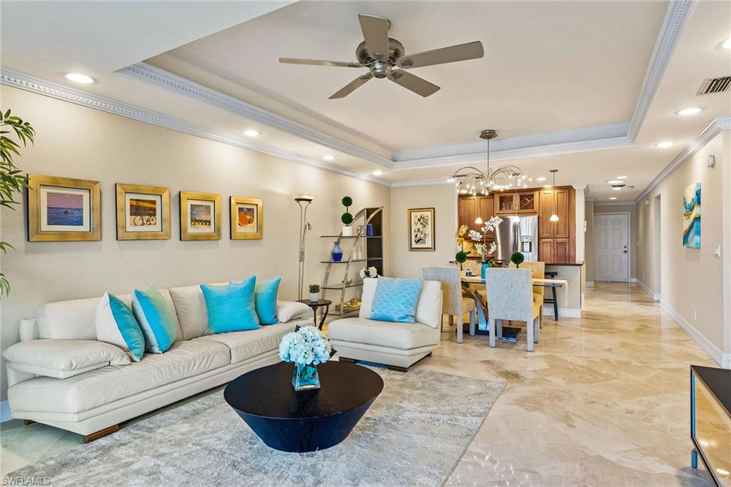 9101 Vanderbilt Drive, Unit 301 Naples, FL 34108 - Photo 3 of 28 a living room with furniture kitchen view and a chandelier