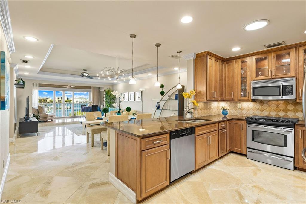 9101 Vanderbilt Drive, Unit 301 Naples, FL 34108 - Photo 8 of 28 a kitchen with stainless steel appliances granite countertop a sink and cabinets