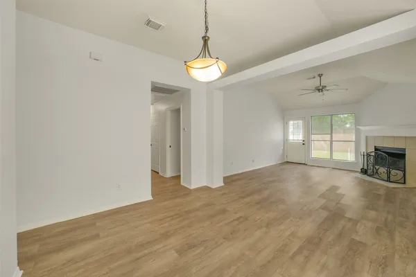 a view of an empty room with a fireplace and a window