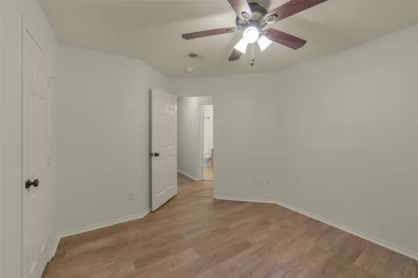 an empty room with closet and a chandelier fan