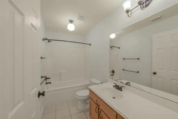 a bathroom with a tub sink toilet and a mirror