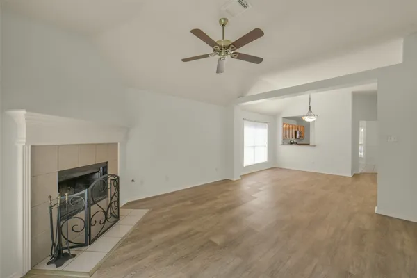 an empty room with fan and windows