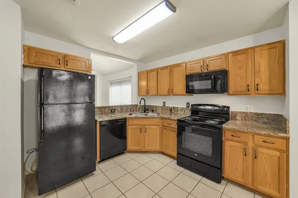 a kitchen with stainless steel appliances granite countertop a refrigerator stove top oven a sink and dishwasher