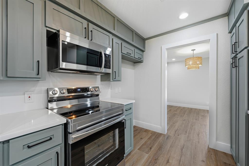 1145 Terrace Trail Hurst, TX 76053 - Photo 12 of 36 a kitchen with stainless steel appliances a stove microwave and cabinets