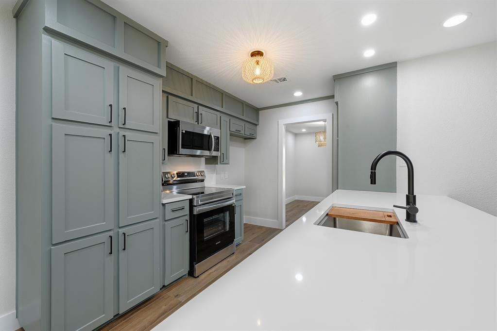 1145 Terrace Trail Hurst, TX 76053 - Photo 13 of 36 a kitchen with kitchen island a sink stainless steel appliances and cabinets