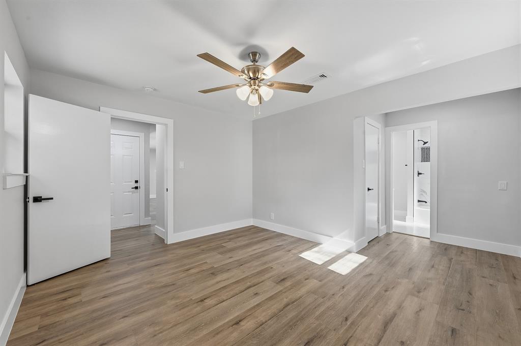 1145 Terrace Trail Hurst, TX 76053 - Photo 24 of 36 a view of an empty room with window a ceiling fan and wooden floor