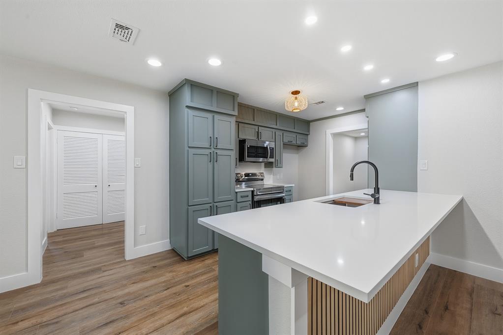 1145 Terrace Trail Hurst, TX 76053 - Photo 7 of 36 a kitchen with kitchen island a sink and wooden floor