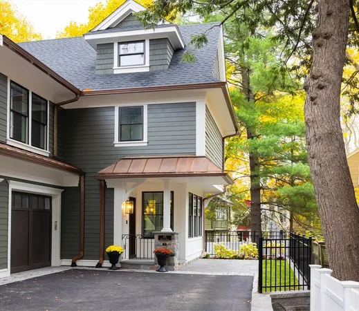 a view of a brick house with large windows and a small yard