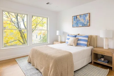 a bedroom with a bed and a painting on the wall