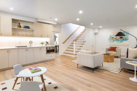 a living room with furniture and a wooden floor
