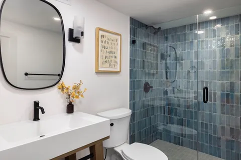 a bathroom with a sink mirror toilet and shower