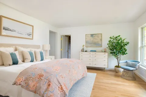 a bedroom with a bed and a potted plant