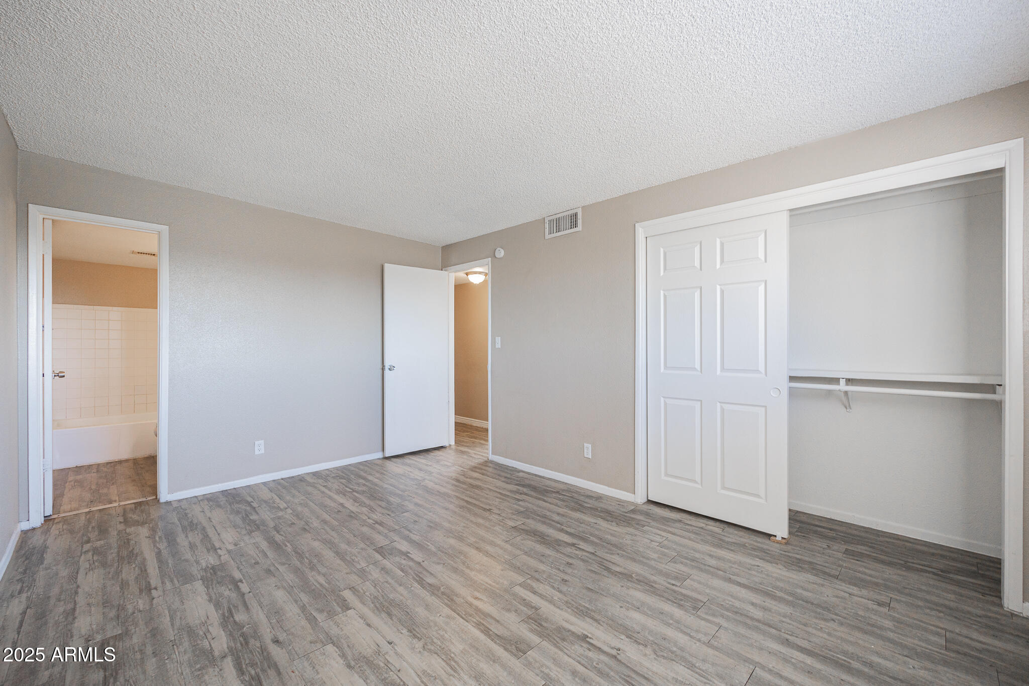 2411 West Hazelwood Street, Unit 278 Phoenix, AZ 85015 - Photo 13 of 20 a view of an empty room with wooden floor