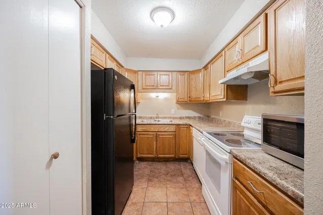 a kitchen with a refrigerator sink and cabinets