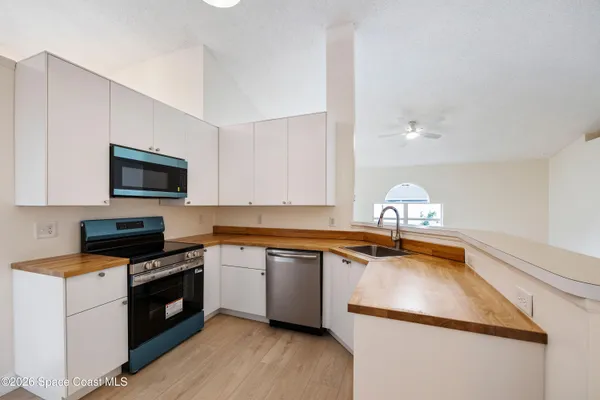 a kitchen with a sink a stove and cabinets