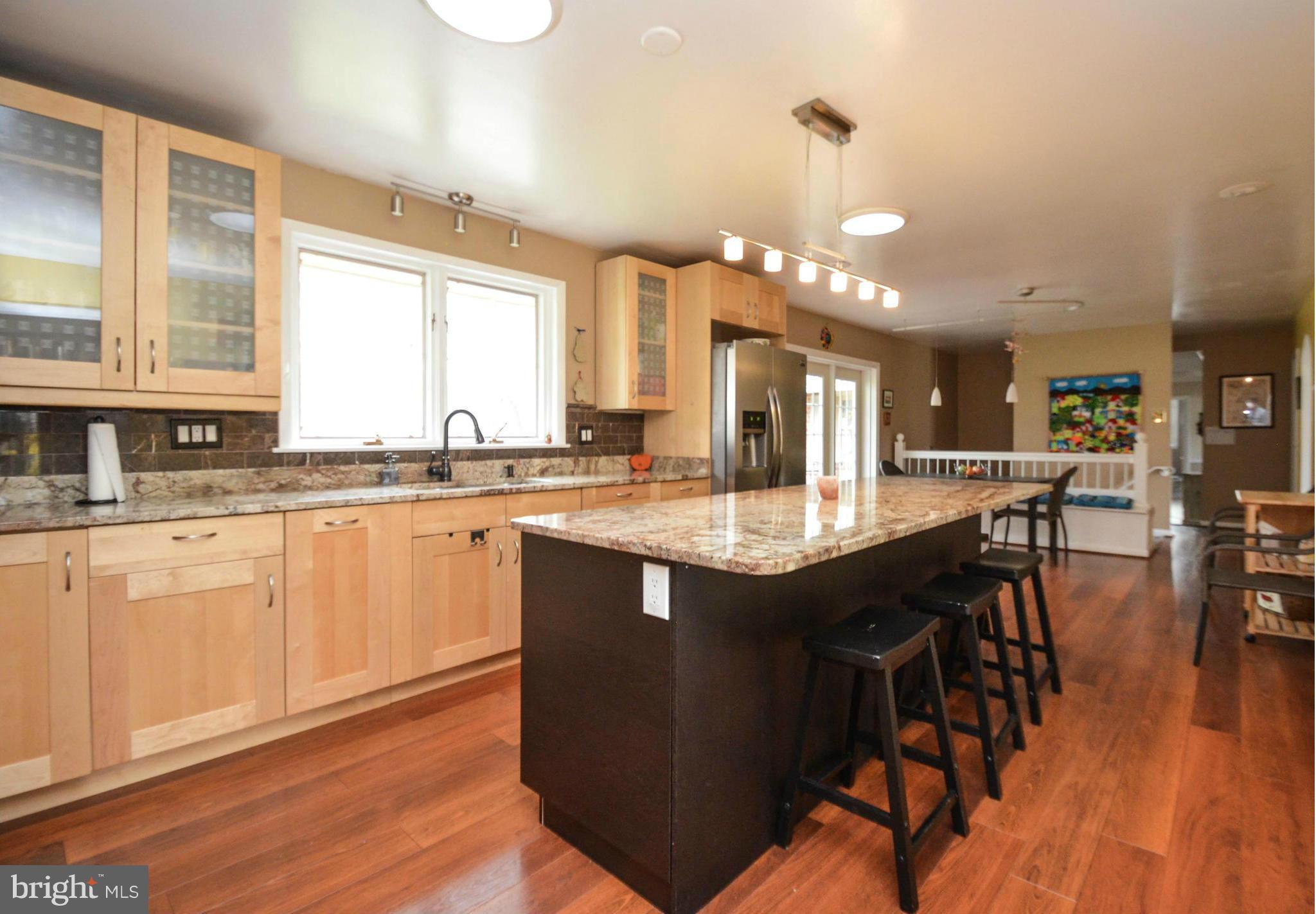 901 Huntsman Road Towson, MD 21286 - Photo 4 of 30 a kitchen with granite countertop a stove a sink a dining table and chairs