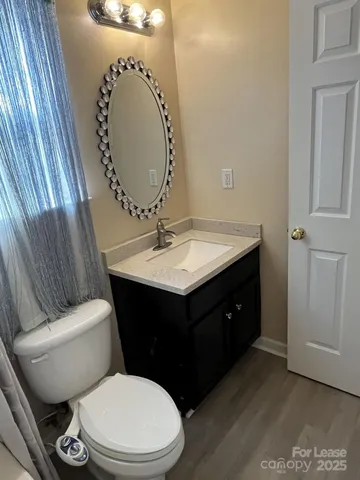 a bathroom with a sink vanity mirror and toilet