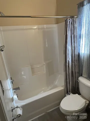 a bathroom with a toilet and a shower