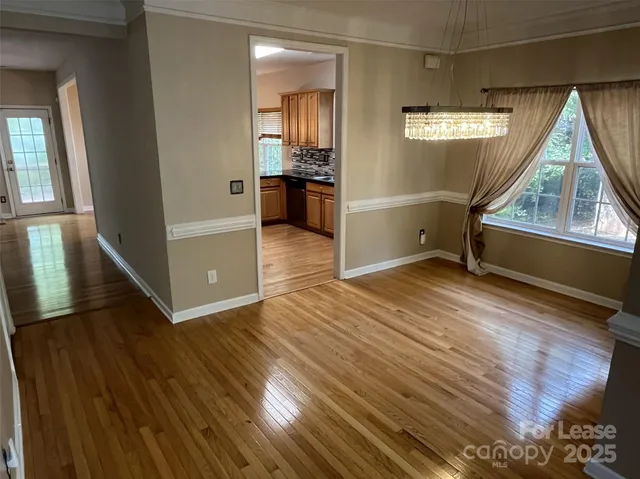 a view of empty room with kitchen and window