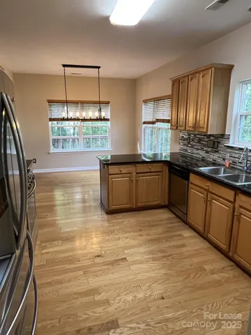 a kitchen with stainless steel appliances granite countertop a sink and wooden cabinets