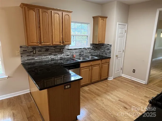 a kitchen with stainless steel appliances granite countertop a sink stove and cabinets
