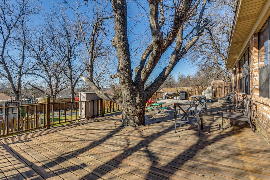 1304 South Hatcher Street Decatur, TX 76234 - Photo 36 of 36 a view of a patio with table and chairs with wooden fence and floor