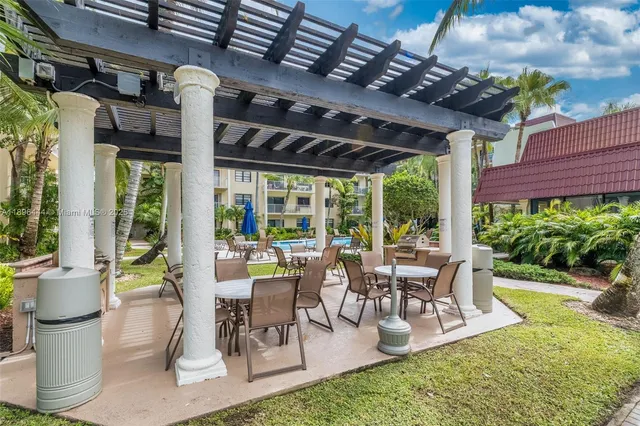 a view of a patio with table and chairs potted plants and floor to ceiling window