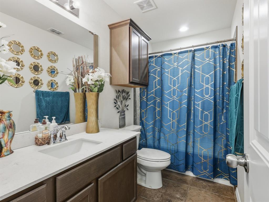 425 Merry Mill Road Wilmer, TX 75172 - Photo 14 of 29 a bathroom with a granite countertop sink a toilet and a shower curtain