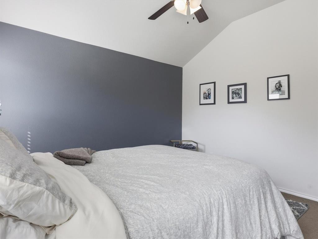 425 Merry Mill Road Wilmer, TX 75172 - Photo 18 of 29 a bedroom with a bed and a chandelier