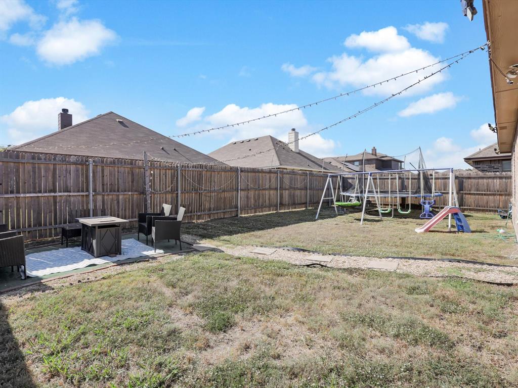 425 Merry Mill Road Wilmer, TX 75172 - Photo 24 of 29 a view of a backyard with a bench and wooden fence