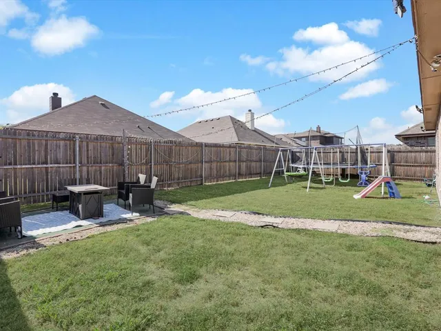a view of a backyard with a bench and wooden fence