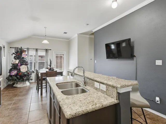 a kitchen with a sink a counter and chairs