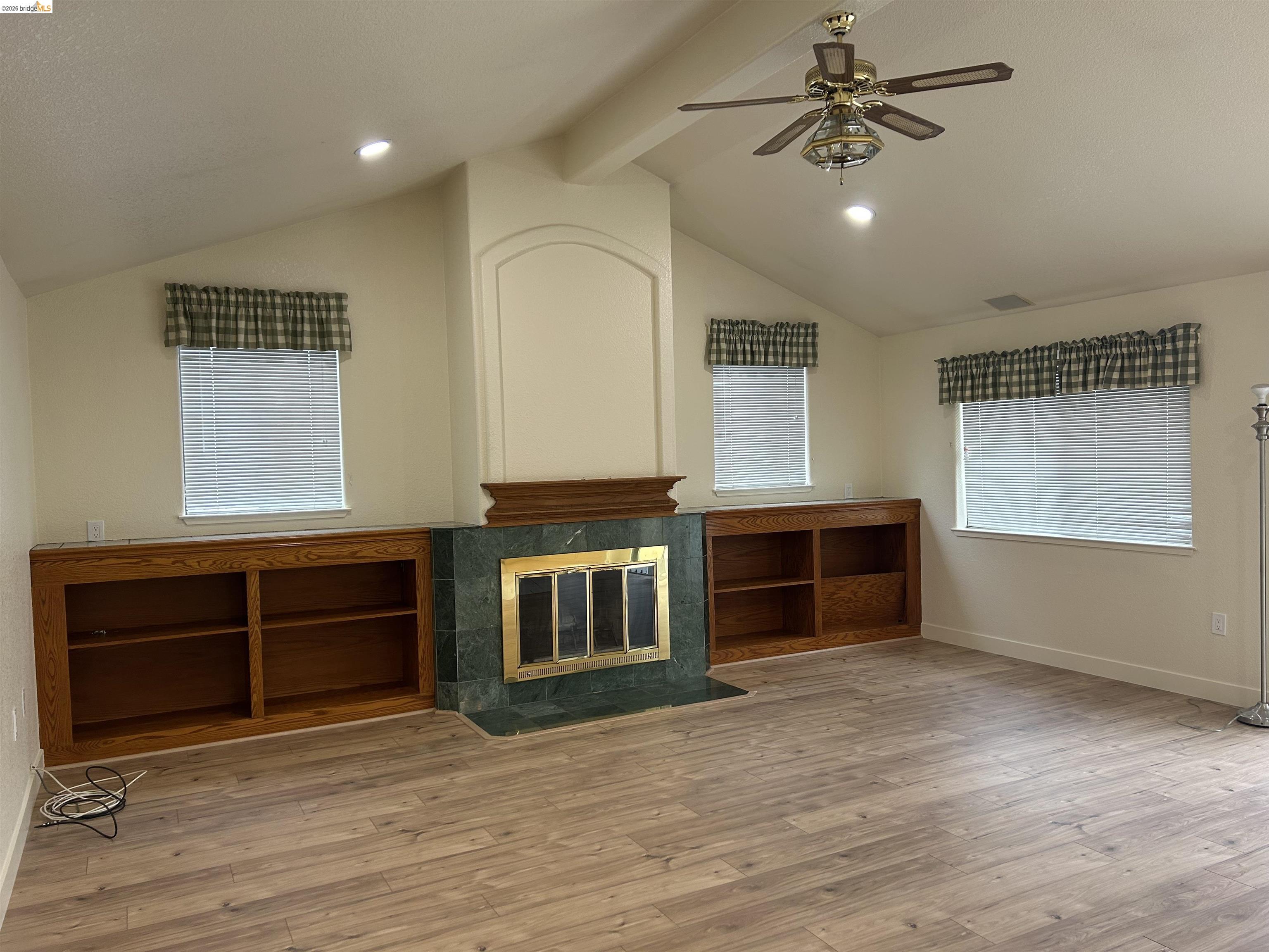2632 Point Lobos Court Antioch, CA 94531 - Photo 11 of 27 Unfurnished living room featuring ceiling fan, recessed lighting, light wood finished floors, a tiled fireplace, and beamed ceiling